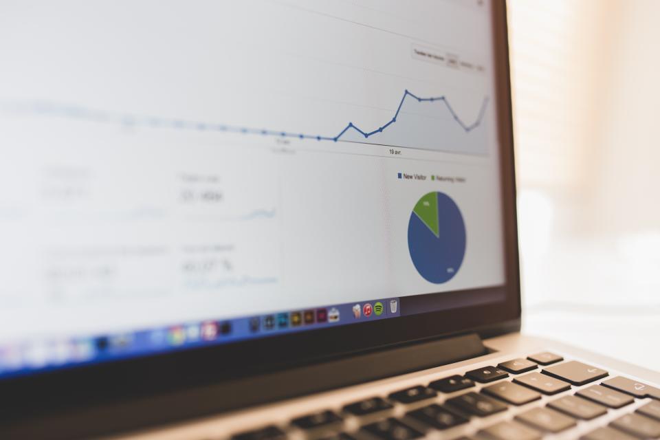 Laptop screen showing analytics charts for a growing business