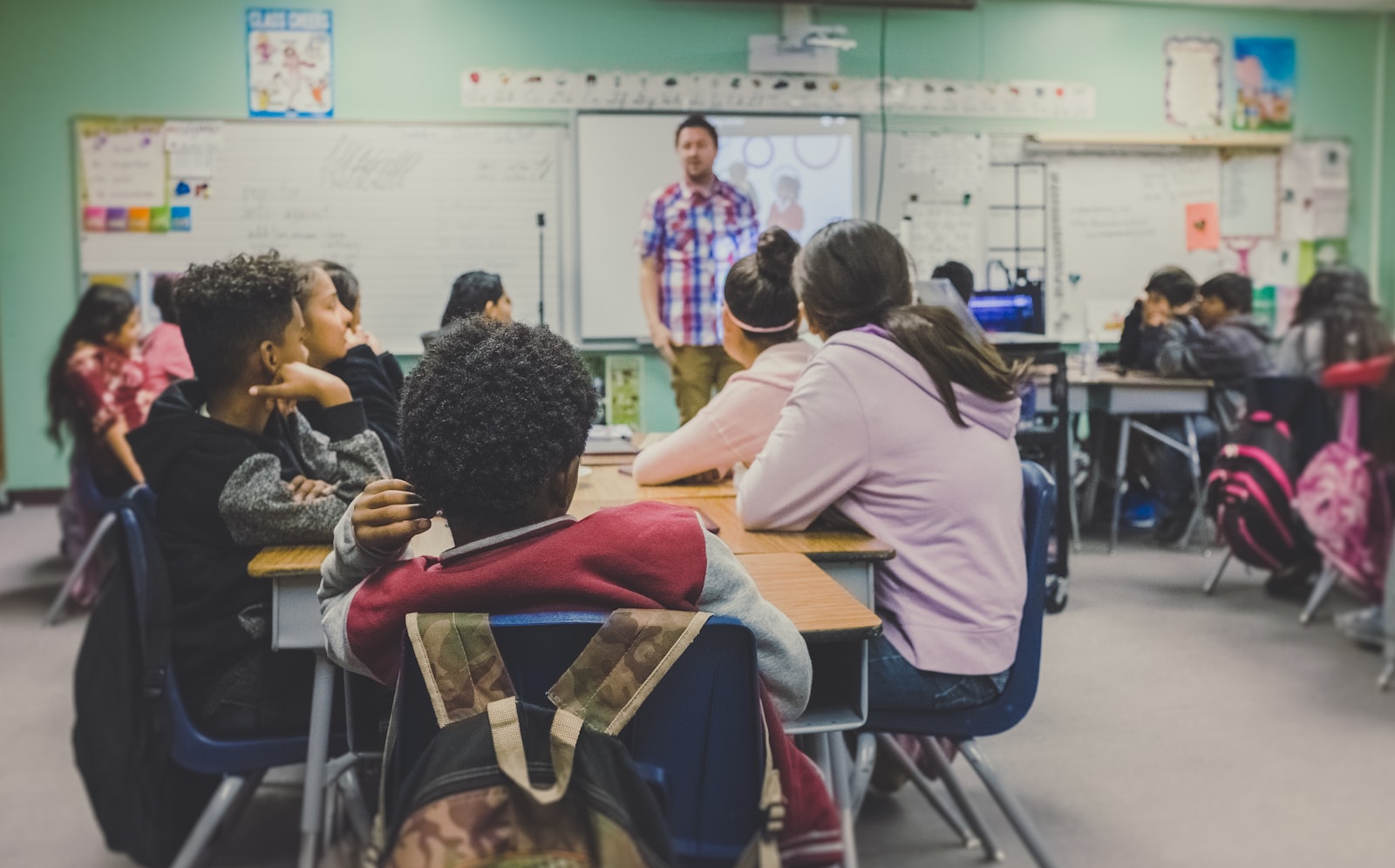 Pupils working with a teacher in a school classroom