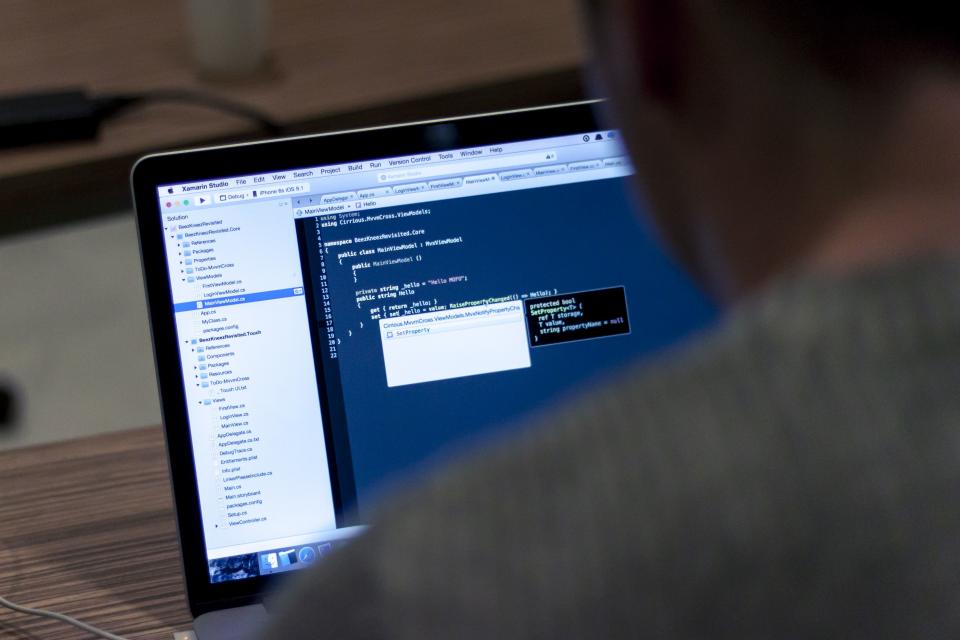 Software engineer writing code on a dual-screen setup