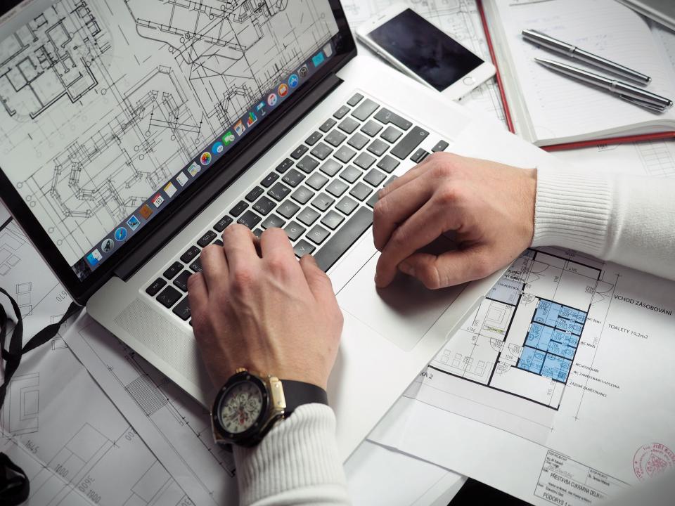 Planning documents and a laptop on a project desk