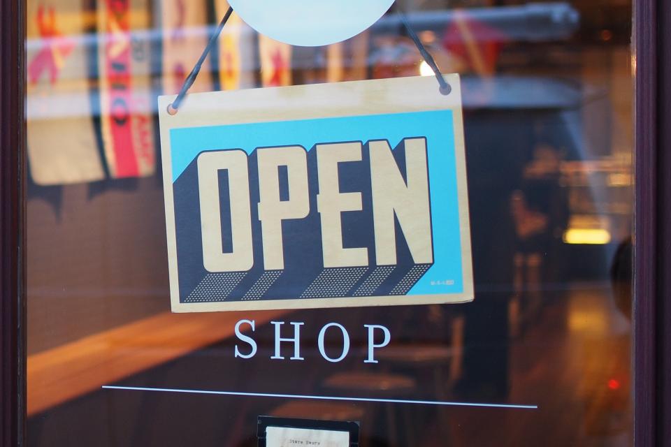 Open sign hanging in the window of a small retail store