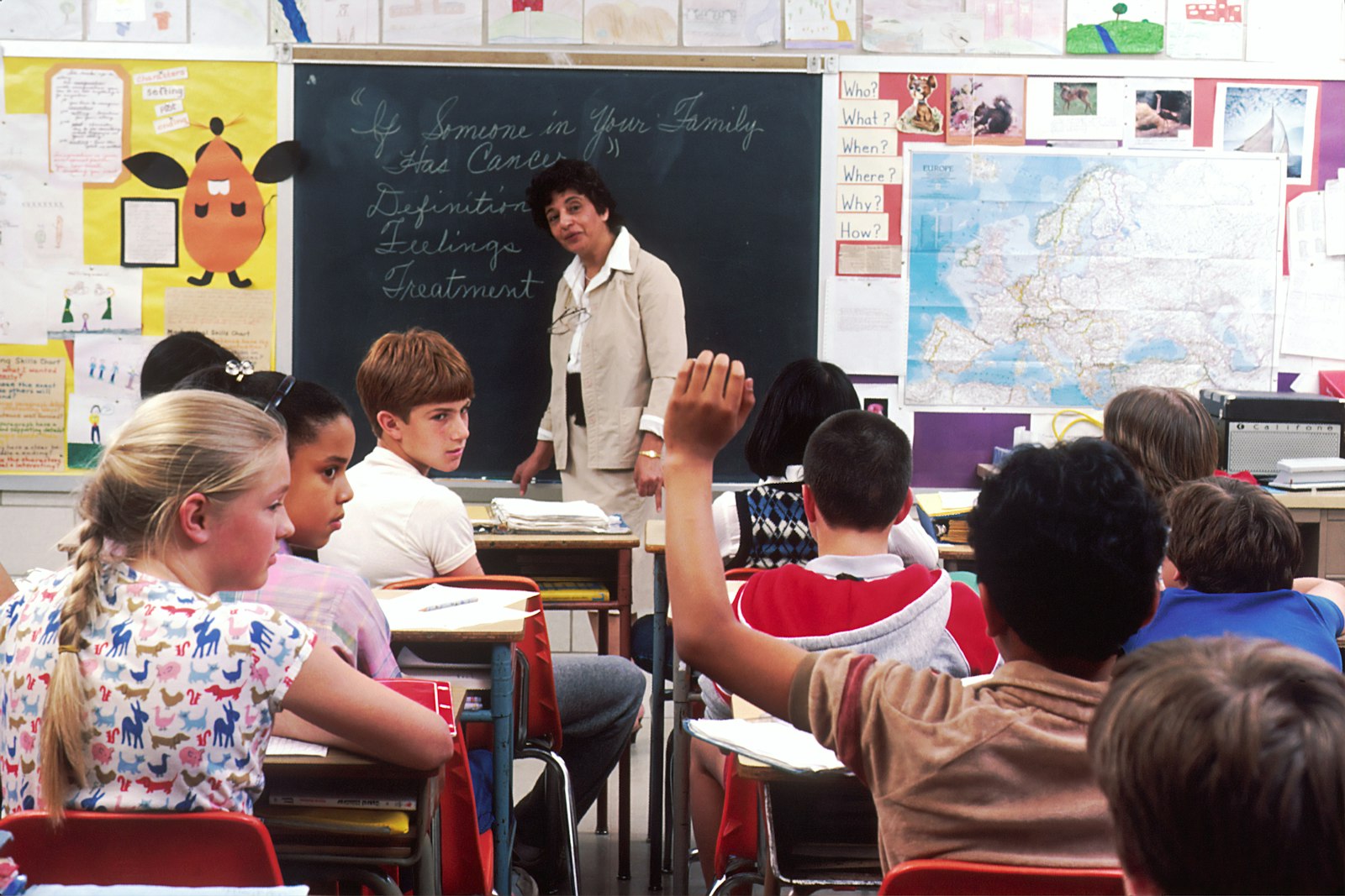 Teacher speaking with pupils in a classroom